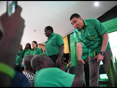 Party leader Andrew Holness greets a supporter at the JLP’s Area Council Two meeting at the Portmore HEART Academy in St Catherine.