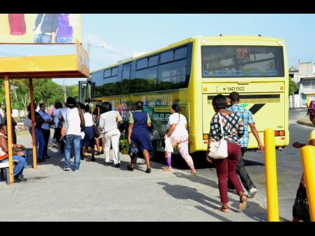 Commuters prepare to board a JUTC bus that plies the Spanish Town to Half-Way Tree route.