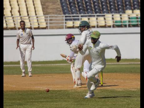 Leeward Islands Hurricanes batsman Devon Thomas sweeps for four against Patrick Harty Jr (left) in action from yesterday’s West Indies Championship match at the Trelawny Multi-purpose Stadium.