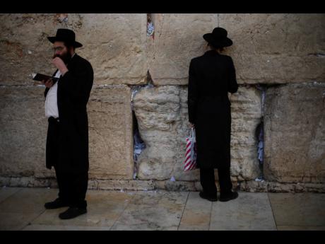 Jews pray at the Western Wall, the holiest site where Jews can pray in Jerusalem’s Old City, yesterday. As concerns over the coronavirus’ spread rise, Jewish faithful held a prayer session Sunday at the wall in search of divine intervention to help stave off the contagious disease.