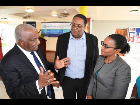 Claudine Allen (right), executive, member relations at The Jamaica National Group, and Professor Michael Taylor (centre), dean, Faculty of Science and Technology at The University of the West Indies, Mona, listen keenly to a point being made by Dr Glen Christian, convenor of the Science, Technology, Engineering and Mathematics for Growth Task Force, during the recent launch of the Forecast 2020 Conference.
