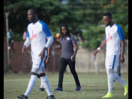 Portmore United coach Ricardo Gardner (centre) walks across the field at half time during a Red Stripe Premier League match against Dunbeholden at the Spanish Town Prison Oval earlier this season.