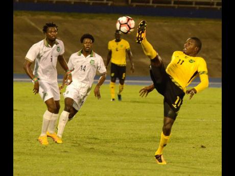 In this November 2016 file photo, national striker Corey Burke  (right) stretches high to try control the ball ahead of Guno Kwasi (left) and Sergino Eduard (centre) of Suriname during their CFU Caribbean Cup qualifier at the National Stadium in Kingston.