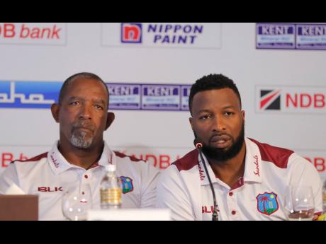 Windies’ captain Kieran Pollard (right) speaks to the media as coach Phil Simmons watches during the inauguration of the NDB series trophy in Colombo, Sri Lanka on Wednesday.