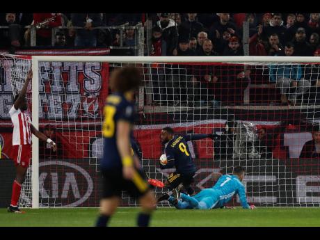 Arsenal’s Alexandre Lacazette (second right) grabs the ball from the back of the net after scoring the lone goal of the game against Olympiakos during the Europa League round of 32, first leg match at the Georgios Karaiskakis Stadium in Piraeus Port, near Athens yesterday.