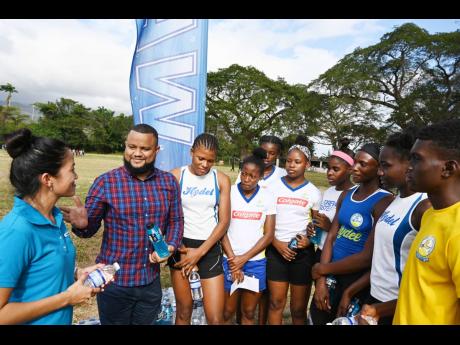 Sponsors Melissa Lue Yen (left), Food Service Business Manager, Wisynco Group Limited and Ryan Foster (second left), Chairman, Express Canteen, talk with members of Hydel High School’s track and field team during a sponsorship presentation, at their Caymanas Estates training ground on Tuesday. The athletes are (from third left) Thaila Wilson, Oneika McAnuff (partly hidden), Garriel White (girls captain), Ray-Donna Lee, Cherokee Young, Ashanti Moore, Rihanna Phipps and Jaheim Diosi (boys captain).