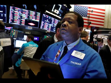 Trader Thomas Lee works on the floor of the New York Stock Exchange, Friday, February 28, 2020. The market had its worst week since 2008 due to uncertainties sorrounding the coronavirus.