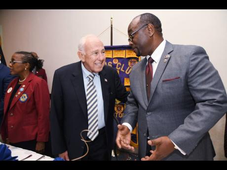 US Ambassador Donald Tapia (left) has a light moment with Robert Lawrence, president of the Lions Club of Kingston, at a luncheon meeting at The Jamaica Pegasus in New Kingston on Wednesday.