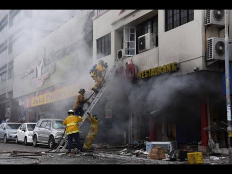 Firemen battle a blaze at TAO Restaurant Chinese Cuisine on Knutsford Boulevard, New Kingston, yesterday morning.
