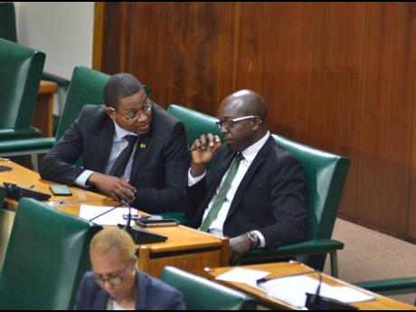Clarendon South East Member of Parliament Pearnel Charles Jr (right) listens to his colleague Floyd Green, St Elizabeth South West MP, in Gordon House on Thursday shortly after Charles Jr was sworn in yesterday.