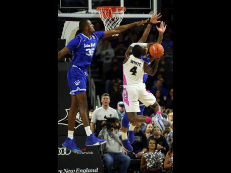 
Seton Hall’s Romaro Gill (left) and Shavar Reynolds Jr (back right) attempt to block a shot by Providence’s Maliek White (4) during the first half of an NCAA college basketball game on Saturday, February 15 in Providence, Rhode Island.