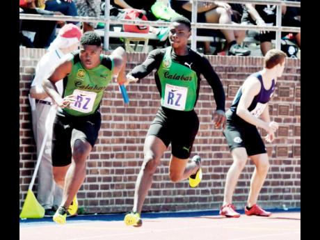 Calabar High’s DeJour Russell (left) is off after receiving the baton from Michael Stephens at the Penn Relays in 2017. Calabar won the heat in 39.98 seconds.