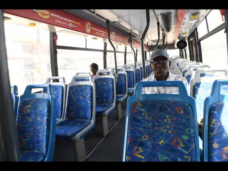 Two JUTC passengers sitting in the bus at the Half-Way Tree Transport Centre in Kingston on Monday, March 16.