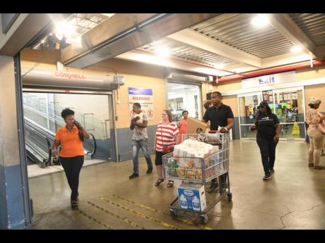 Shoppers exit the PriceSmart store in Kingston on March 17. The chain is considering a commercial development in Montego Bay but is still to decide whether it will open a third store there.