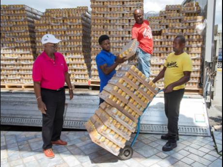 From left: Minister of Local Government and Community Development Desmond Mckenzie, was on-site as Kyle Giscombe, a volunteer from the ministry, Dean Taylor, and Devrol Smith unload Red Stripe’s donation of 1,500 cases of Malta. The donation, with an approximate retail value of $6 million will go to the island’s 14 infirmaries and three golden age homes managed by parish councils. 