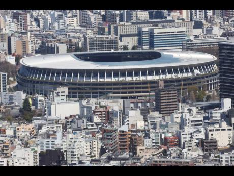 The new national stadium, a venue designed for the opening and closing ceremonies for the Tokyo 2020 Olympics, is seen prominently at the background in Tokyo, Japan, on Wednesday.