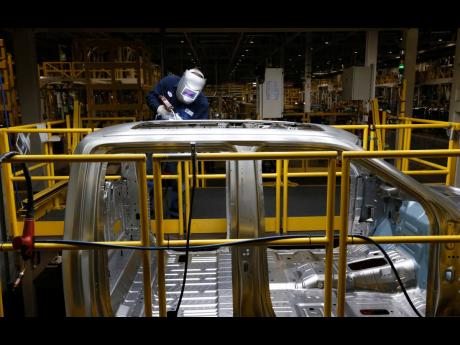 AP
In this November 11, 2014 photo, Ron Hudgins welds a 2015 Ford F-150 cab at the Dearborn Truck Plant in Michigan.