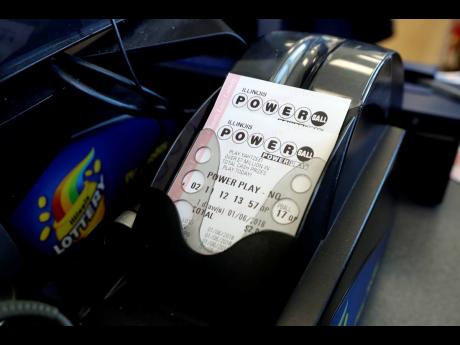 AP
Powerball lottery tickets are printed out of a lottery machine at a convenience store, in Chicago. 