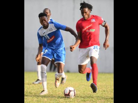 Portmore United’s Shai Smith (left) and Dunbeholden’s Shaquille Dyer battle for the ball during a Red Stripe Premier league encounter at the Spanish Town Prison Oval on December 1 last year.