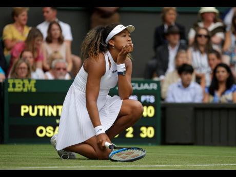 Japan’s Naomi Osaka reacts in disappointment as she plays Kazakstan’s Yulia Putintseva in a Women’s singles match during day one of the Wimbledon Tennis Championships in London, Monday, July 1, 2019. 