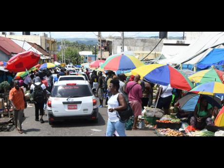Shoppers and market vendors jostle for space in Linstead, St Catherine, on Tuesday, a day before an islandwide curfew took effect. Crowded markets are of concern to state officials because they are potential incubators for community spread of the novel coronavirus. 
