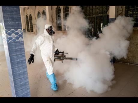 A municipal worker sprays disinfectant in a mosque to help curb the spread of the new coronavirus in Dakar, Senegal on Wednesday. (AP)