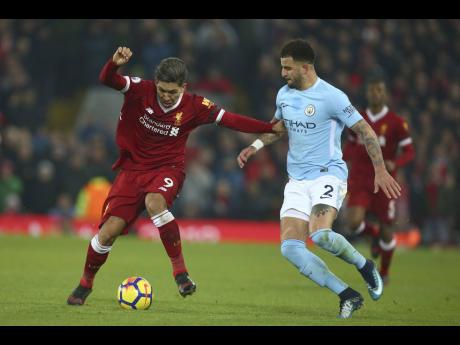 Manchester City’s Kyle Walker (right) hassles Liverpool’s Roberto Firmino for the ball during their English Premier League match at Anfield Stadium, in Liverpool, England on Sunday, January 14, 2018. 