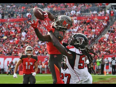 Tampa Bay Buccaneers wide receiver Breshad Perriman (centre) pulls in a 24-yard touchdown reception in front of Atlanta Falcons outside linebacker De’Vondre Campbell (right) during the first half of an NFL football game in Tampa, Florida on Sunday, December 29, 2019.