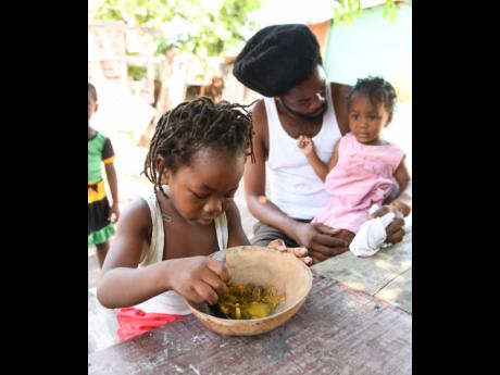 Leonard Sinclair spends family time with his children, four-year-old Lenmar and two-year-old Lenora, at 2 Marcus Garvey Drive, Kingston, on Sunday. As COVID-19 and curfews redefine the boundaries of movement for Jamaicans, many are using the time to bond more at home.