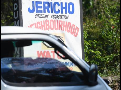 A motorist drives by a sign in the community of Jericho, just outside Linstead, in St Catherine yesterday.