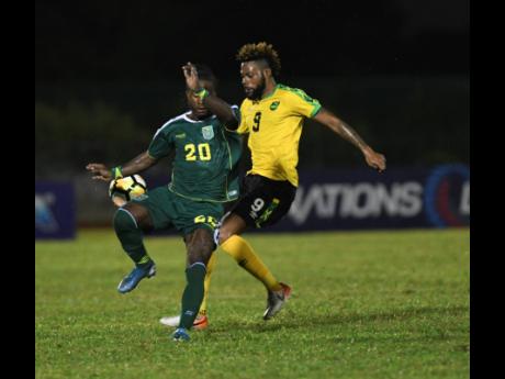 Jamaica’s Ricardo Morris (right) gets up close with Guyana’s Trayon Bobb to make a challenge during their Concacaf Nations League match at the Montego Bay Sports Complex on Monday, October 18, 2019. Social-distancing protocol requires persons to stay at least three feet away from each other to help curtail the transmission of COVID-19, posing questions for the resumption of contact sports such as football.