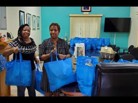 Sharon Irons-Francis (left), president of Denbigh High School PTA, and principal Janice Julal prepare to deliver care packages.