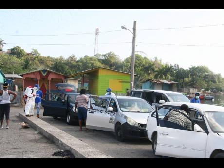 Taxis being sanitised in the Lucea Transport Centre under an initiative lauched by Hanover Strong on Sunday.