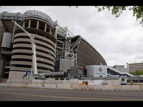 Constuction workers stand by Real Madrid’s Santiago Bernabeu Stadium in Madrid, Spain, on Thursday. 