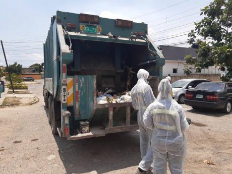 Garbage collectors making a pickup in Cumberland, St Catherine, one of the communities under quarantine.