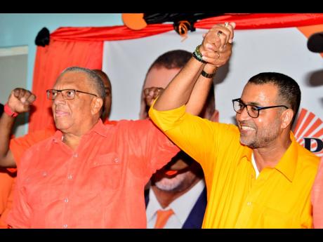 PNP President Dr Peter Phillips (left) endorses Dr Winston De La Haye, the prospective candidate for the St Catherine East Central constituency, during a party meeting at Cedar Grove Academy.