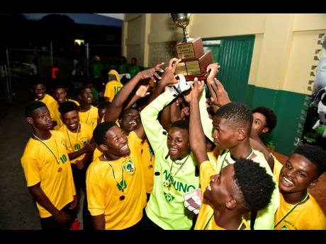 Excelsior High School footballers hoist the Ali Cup  to celebrate winning the tournament at the Courtney Walsh Oval on Saturday, July 20, 2019.