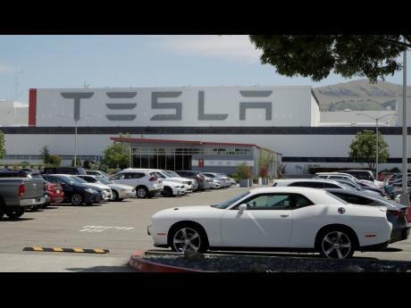 Vehicles are seen parked at the Tesla car plant on Monday, May 11, 2020, in Fremont, California.