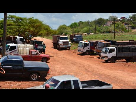 Truckers gather at a well in Cheapside, St Elizabeth, as they have been forced to find alternative sources because of a worsening dispute with the JISCO bauxite plant in Nain.