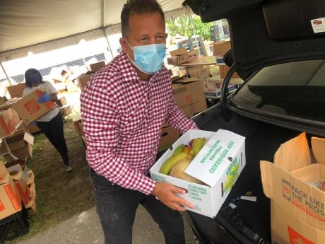 
Consular General Oliver Mair preparing care packages in South Florida. Members of the Caribbean diaspora are among those hit with unemployment and salary cuts in the United States, with many finding it harder to send remittances to their families back home.
