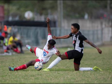 Cavalier FC’s Ronaldo Webster (right) puts in a tackle on UWI FC’s Nacquain Brown during a Red Stripe Premier League game at the UWI Mona Bowl on Sunday, February 23.