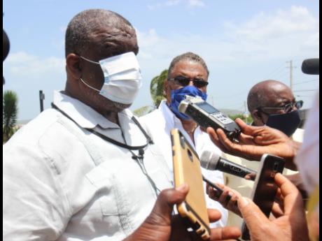Errol Greene, regional director of the Western Regional Health Authority, fields questions from the media yesterday. Looking on is Opposition Spokesman on Tourism Wykeham McNeill. They were on hand to witness the docking of the Adventure of the Seas cruise ship on which 1,044 Jamaicans are aboard.