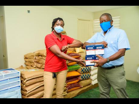 Nicola Morris, administrator at the Black River Hospital and a board member of directors’ warden at the All Souls Anglican Church is delighted to receive masks from Donald Mullings, founder and managing director, M & M Jamaica Limited, for the Black River Hospital.  The donation will benefit the more than 300 staff members at the type ‘C’ facility.  