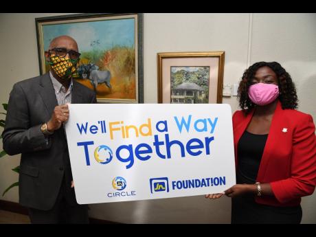 Earl Samuels, assistant general manager, The Jamaica National Group, makes a donation of a $1 million to Cassandra Morrison, executive director of the National Council for Senior Citizens. The donation will assist in providing care packages to senior citizens. The presentation was made recently at the head office of The Jamaica National Group on Constant Spring Road in Kingston.