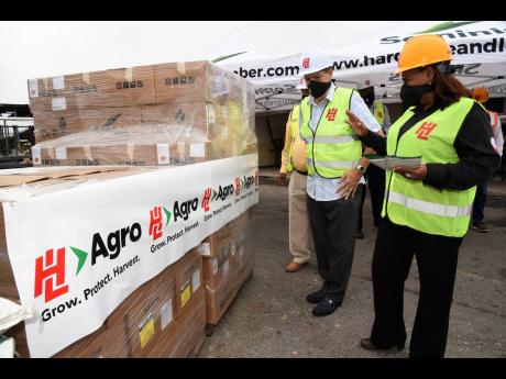 Olive Downer-Walsh (right), deputy chief executive officer of Hardware & Lumber, shows Agriculture and Fisheries Minister Audley Shaw $2 million worth of agricultural inputs the company donated to the ministry on Thursday. The donation was made in an effort to support the Government’s COVID-19 recovery programme for farmers. 