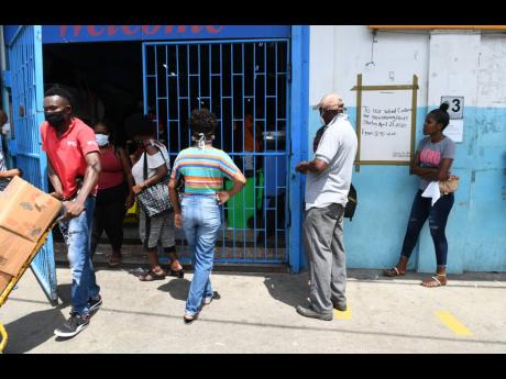 Residents from St Mary stand in line at a wholesale in Port Maria.