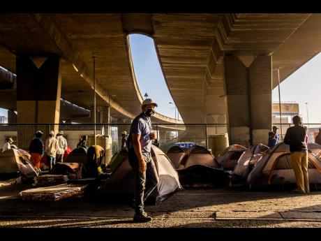 Homeless people living in tents under a bridge in Cape Town, South Africa, on Friday, May 22, after being transported from a closed shelter to another unfinished shelter.