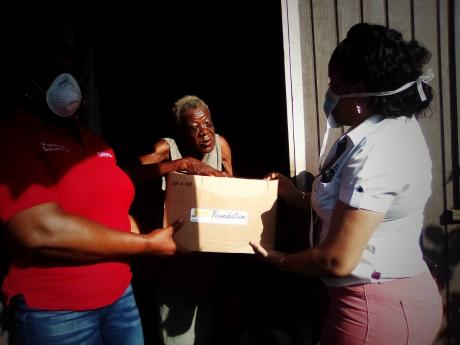 Luna Hall (centre) receives a care package from Shelly Morgan.