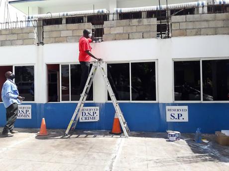 Superintendent of Police Gary Francis painting a section of the Mandeville Police Station on Labour Day. 