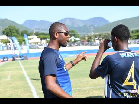 Jamaica College head coach Davion Ferguson gives instructions to one of his players during a Manning Cup match last season.